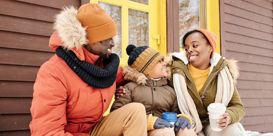 A family sits outside during the winter.